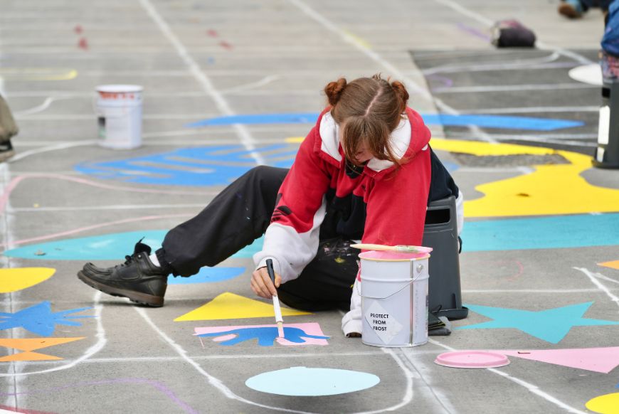 a child painting on the street